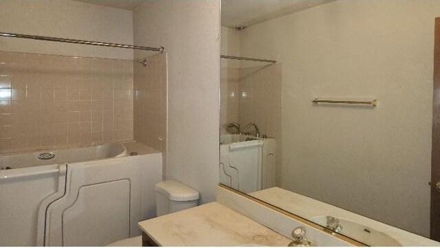 6377 N Genoa Ave, Fresno, CA 93722 - bathroom featuring toilet, vanity, and tub / shower combination