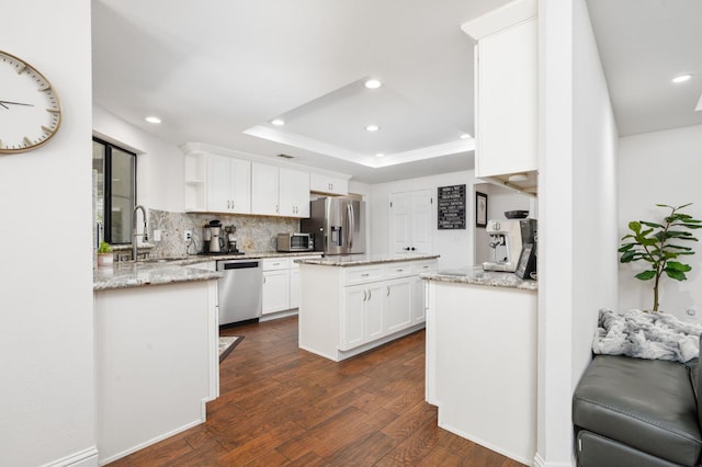8814 N Spalding, Fresno, CA 93720 - kitchen with stainless steel appliances, a sink, a center island, dark wood finished floors, and a tray ceiling