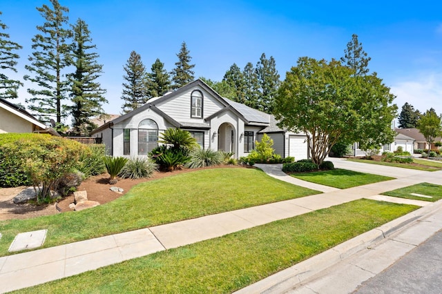 8814 N Spalding, Fresno, CA 93720 - view of front of house with solar panels, concrete driveway, an attached garage, a front lawn, and stucco siding