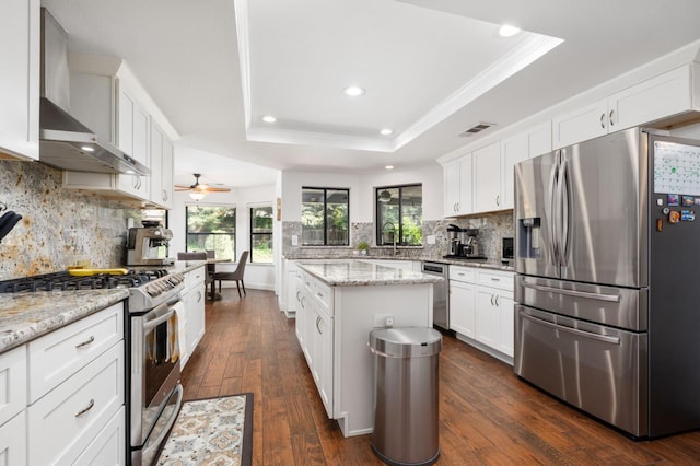 8814 N Spalding, Fresno, CA 93720 - kitchen with stainless steel appliances, wall chimney range hood, a raised ceiling, recessed lighting, and white cabinetry