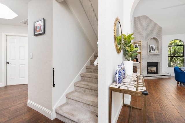 8814 N Spalding, Fresno, CA 93720 - stairway with wood finished floors, a brick fireplace, baseboards, and a skylight