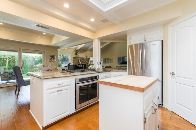 499 E Braddock Dr, Fresno, CA 93720 - kitchen featuring appliances with stainless steel finishes, butcher block countertops, a center island, white cabinetry, and ornamental molding