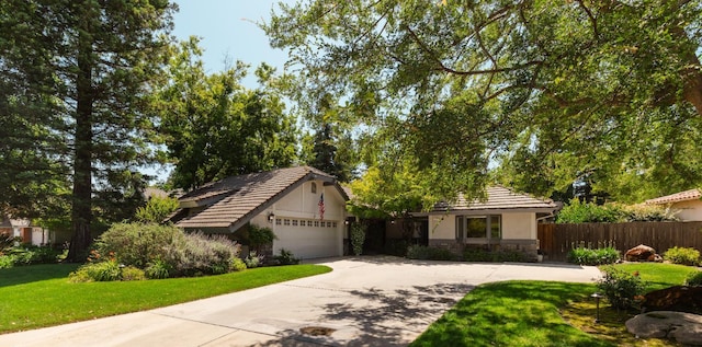 499 E Braddock Dr, Fresno, CA 93720 - view of front of house with stone siding, driveway, stucco siding, and an attached garage