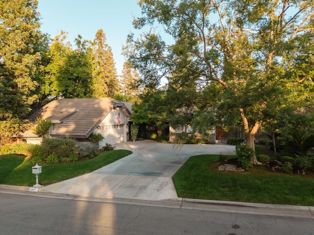 499 E Braddock Dr, Fresno, CA 93720 - view of front of house with concrete driveway, a front yard, a tile roof, and a garage
