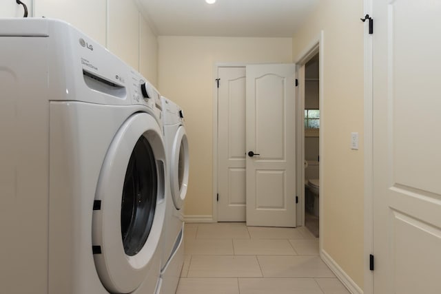 499 E Braddock Dr, Fresno, CA 93720 - washroom featuring washer and clothes dryer, light tile patterned flooring, and baseboards
