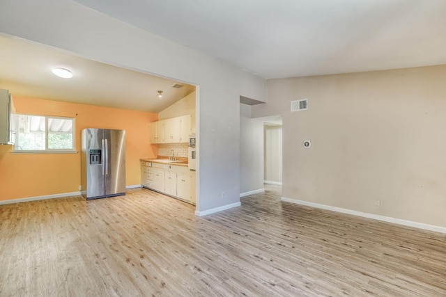 6298 N Glenn Ave, Fresno, CA 93704 - kitchen featuring stainless steel fridge, lofted ceiling, oven, light wood-style flooring, and tasteful backsplash