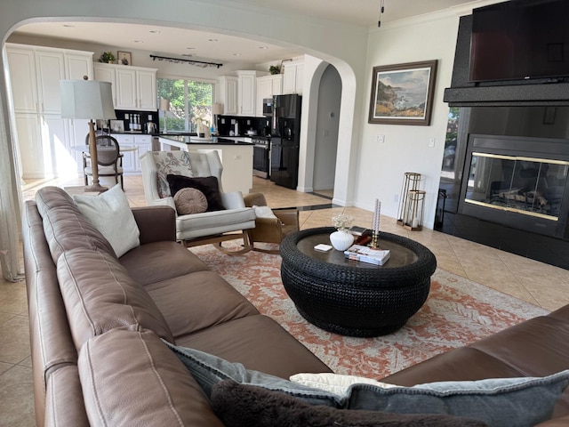 9130 Hunters Creek Way, Chowchilla, CA 93610 - living area with arched walkways, light tile patterned floors, a large fireplace, and ornamental molding
