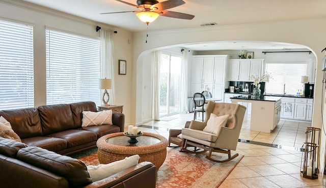 9130 Hunters Creek Way, Chowchilla, CA 93610 - living area with arched walkways, light tile patterned flooring, and a ceiling fan