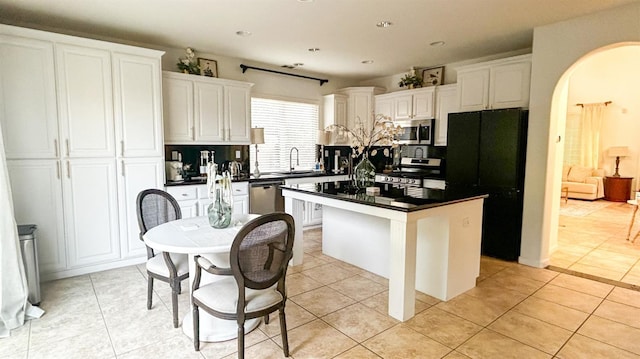9130 Hunters Creek Way, Chowchilla, CA 93610 - kitchen featuring stainless steel appliances, decorative backsplash, white cabinets, dark countertops, and a kitchen island