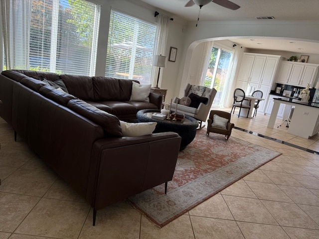 9130 Hunters Creek Way, Chowchilla, CA 93610 - living area with light tile patterned floors, a ceiling fan, arched walkways, and crown molding