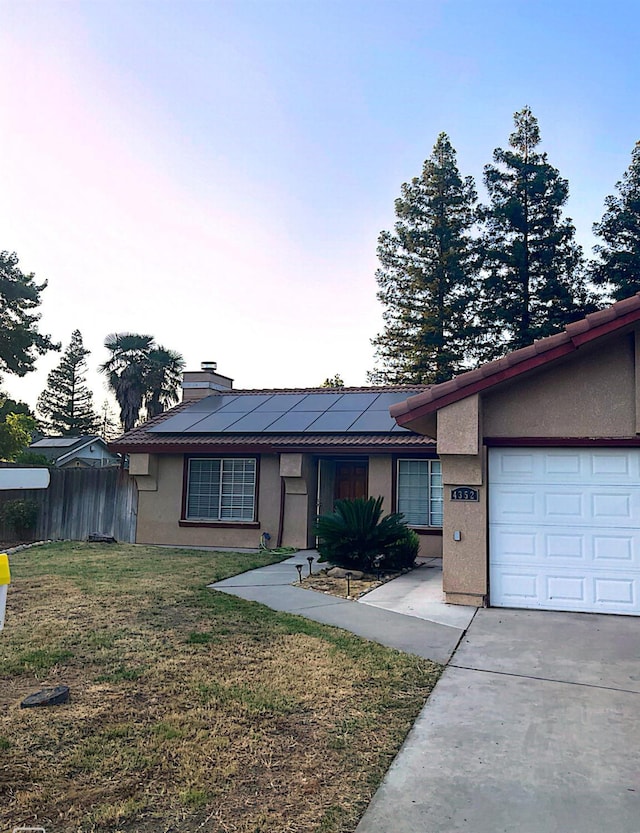 4352 W Los Altos, Fresno, CA 93722 - ranch-style home with stucco siding, solar panels, a garage, and concrete driveway