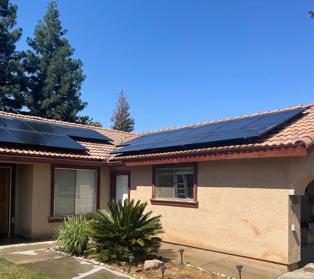 4352 W Los Altos, Fresno, CA 93722 - view of property exterior featuring stucco siding and roof mounted solar panels