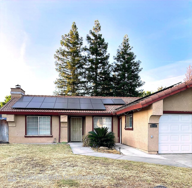 4352 W Los Altos, Fresno, CA 93722 - ranch-style home featuring stucco siding, an attached garage, solar panels, and a tile roof