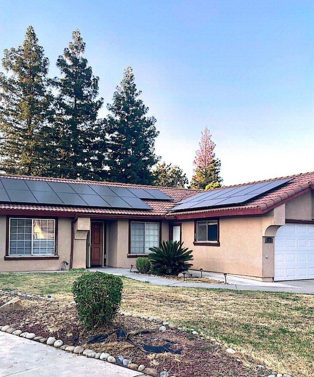 4352 W Los Altos, Fresno, CA 93722 - single story home with stucco siding, an attached garage, solar panels, and a front lawn