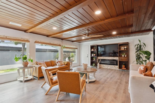 5554 E Montecito Ave, Fresno, CA 93727 - living area featuring wooden ceiling with exposed beams, light wood finished floors, a stone fireplace, and ceiling fan