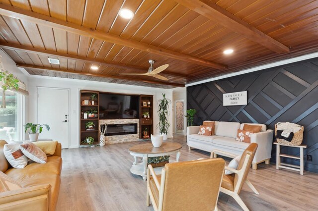 5554 E Montecito Ave, Fresno, CA 93727 - living area featuring wood ceiling with exposed beams, light wood-style floors, a ceiling fan, and a stone fireplace
