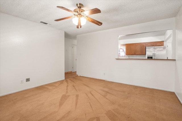 4705 N Holt Ave, Fresno, CA 93705 - unfurnished living room featuring light carpet, ceiling fan, a textured ceiling, and baseboards
