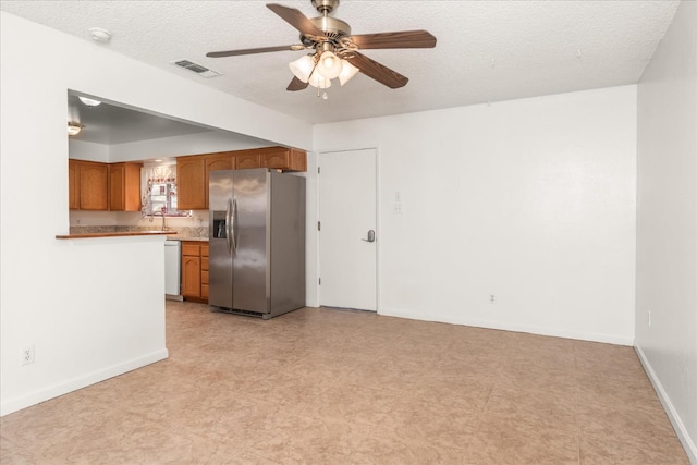 4705 N Holt Ave, Fresno, CA 93705 - unfurnished living room featuring a ceiling fan, baseboards, light flooring, and a textured ceiling