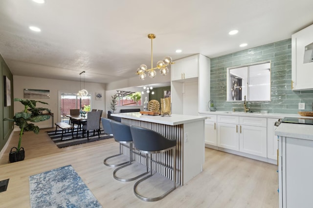 4489 N Chestnut Ave, Fresno, CA 93726 - kitchen featuring a sink, white cabinetry, light countertops, light wood-style flooring, and recessed lighting