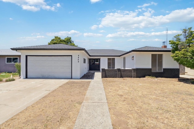 4489 N Chestnut Ave, Fresno, CA 93726 - view of front of house featuring a garage, driveway, and stucco siding