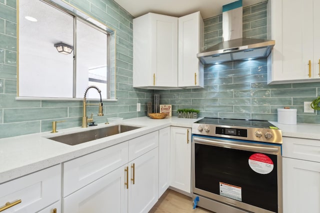 4489 N Chestnut Ave, Fresno, CA 93726 - kitchen with stainless steel electric range oven, a sink, wall chimney exhaust hood, decorative backsplash, and white cabinets