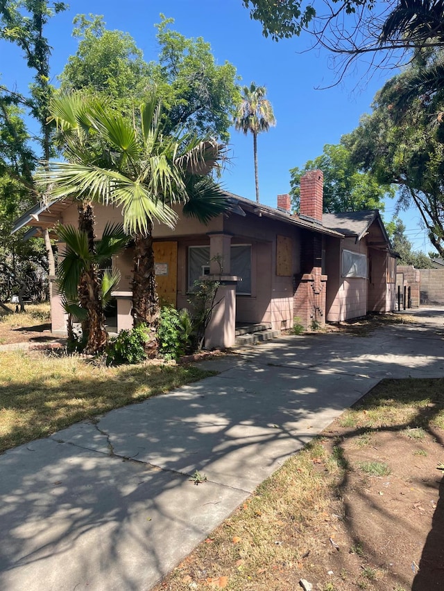 219 E Dennett Ave, Fresno, CA 93728 - view of front facade with a chimney and driveway