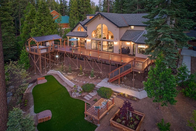 41905 Granite Ridge Rd, Shaver Lake, CA 93664 - back of property with a vegetable garden, a shingled roof, stairs, a wooden deck, and a lawn