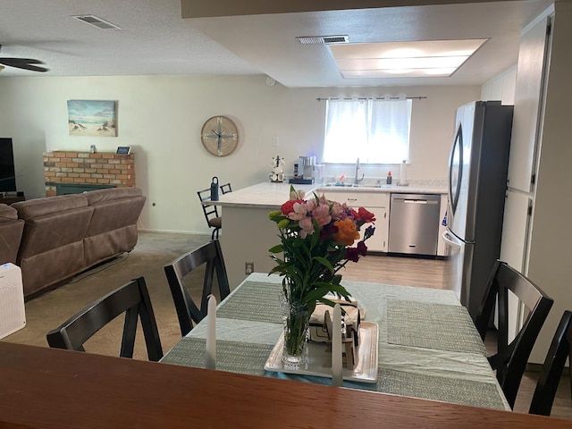 5815 E Lansing Way, Fresno, CA 93727 - dining space featuring a ceiling fan and a brick fireplace