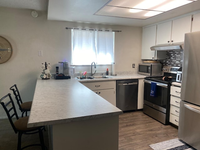 5815 E Lansing Way, Fresno, CA 93727 - kitchen featuring stainless steel appliances, under cabinet range hood, a peninsula, and white cabinetry