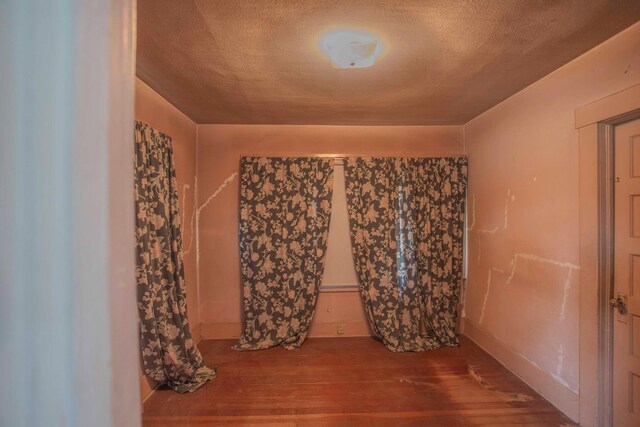 1007 E Michigan Ave, Fresno, CA 93704 - spare room with wood finished floors, a textured ceiling, and baseboards