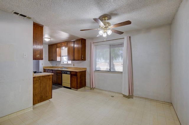 2100 E Linden Ave, Fresno, CA 93725 - kitchen featuring dishwashing machine, a ceiling fan, a sink, light countertops, and brown cabinets