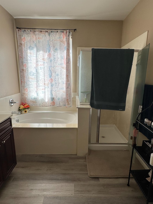 5312 W Cotton Ave, Fresno, CA 93722 - full bathroom featuring a bath, wood finished floors, vanity, and a stall shower
