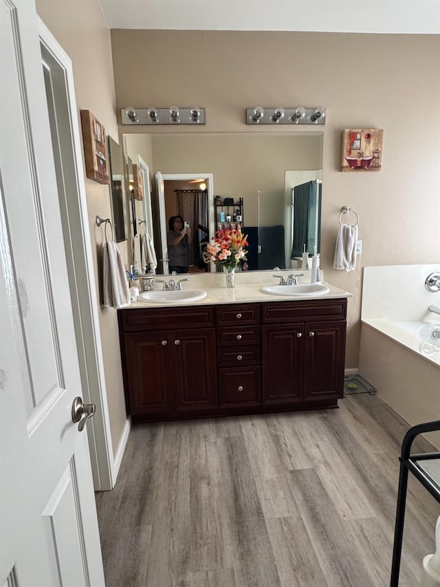 5312 W Cotton Ave, Fresno, CA 93722 - full bath with wood finished floors, a garden tub, double vanity, and baseboards