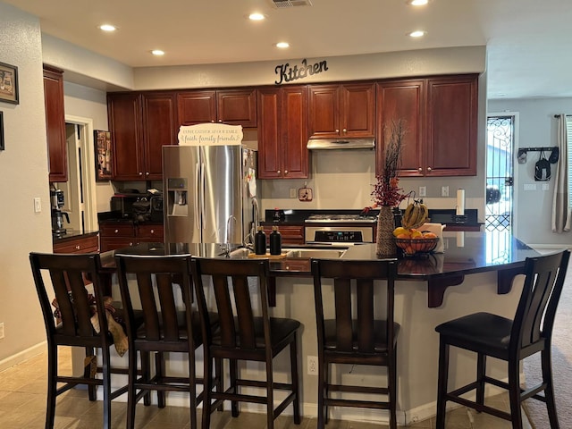 5312 W Cotton Ave, Fresno, CA 93722 - kitchen featuring appliances with stainless steel finishes, under cabinet range hood, recessed lighting, dark countertops, and baseboards