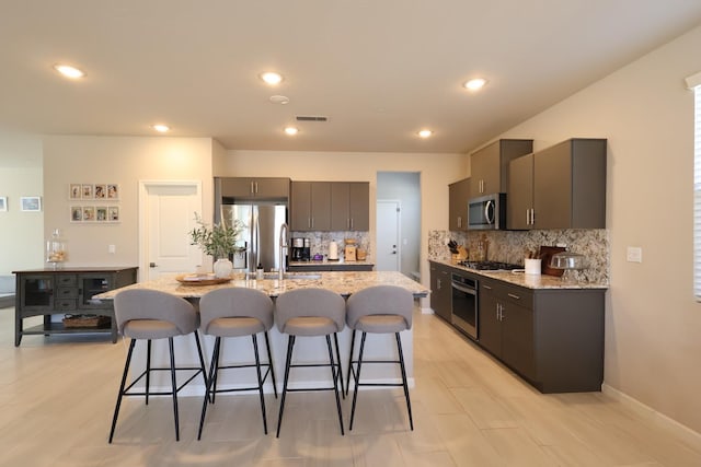 4090 Buckingham Ave, Clovis, CA 93619 - kitchen with appliances with stainless steel finishes, a kitchen bar, backsplash, and recessed lighting