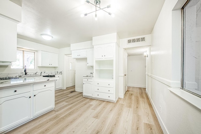 1448 N Helm Ave, Fresno, CA 93727 - kitchen with white cabinets, light wood-style flooring, baseboards, and light countertops
