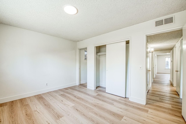 1448 N Helm Ave, Fresno, CA 93727 - unfurnished bedroom featuring a textured ceiling, light wood finished floors, a closet, and baseboards