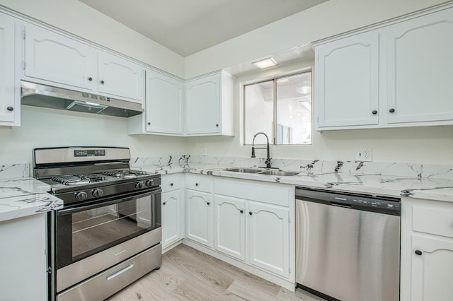 1448 N Helm Ave, Fresno, CA 93727 - kitchen featuring appliances with stainless steel finishes, under cabinet range hood, a sink, white cabinetry, and light wood-style floors