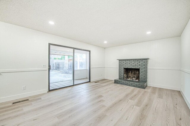 1448 N Helm Ave, Fresno, CA 93727 - unfurnished living room with wood finished floors, recessed lighting, a brick fireplace, and baseboards