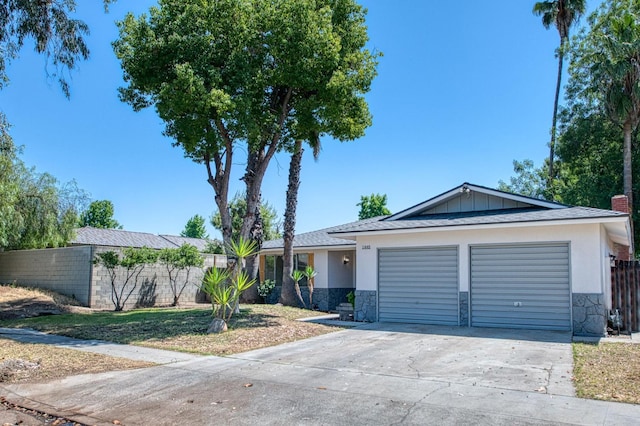 1448 N Helm Ave, Fresno, CA 93727 - ranch-style house featuring stone siding, concrete driveway, a garage, and stucco siding