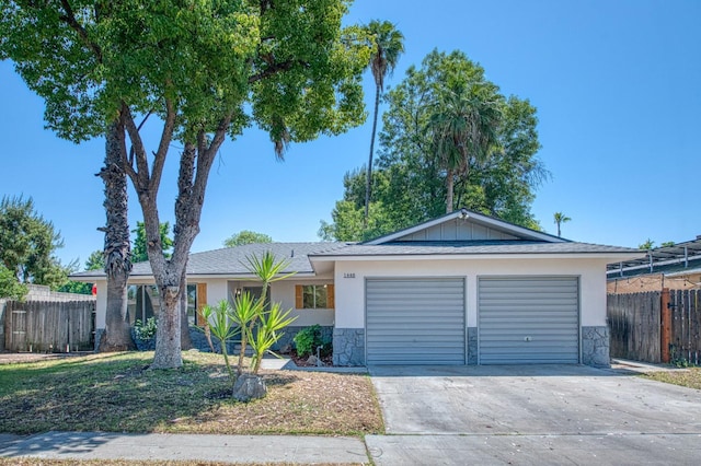 1448 N Helm Ave, Fresno, CA 93727 - ranch-style home with an attached garage, concrete driveway, stone siding, and stucco siding