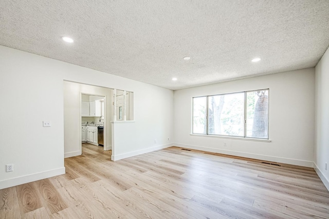 1448 N Helm Ave, Fresno, CA 93727 - empty room with light wood-style flooring, a textured ceiling, recessed lighting, and baseboards
