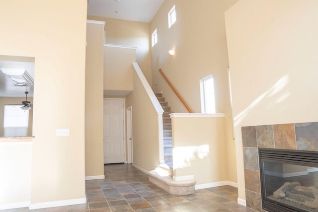1850 N Dupree Ln, Clovis, CA 93619 - unfurnished living room featuring a tiled fireplace, stairway, baseboards, a towering ceiling, and ceiling fan