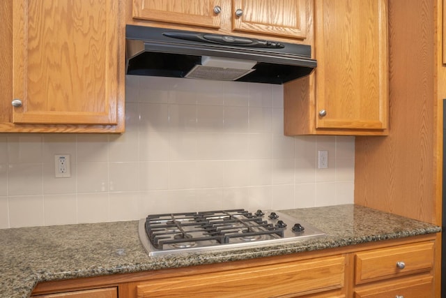 1850 N Dupree Ln, Clovis, CA 93619 - kitchen with under cabinet range hood, stainless steel gas cooktop, tasteful backsplash, dark stone countertops, and brown cabinets