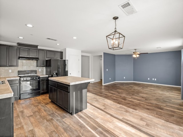 703 Tulip Cir, Dinuba, CA 93618 - kitchen featuring black appliances, light countertops, a ceiling fan, a center island, and tasteful backsplash