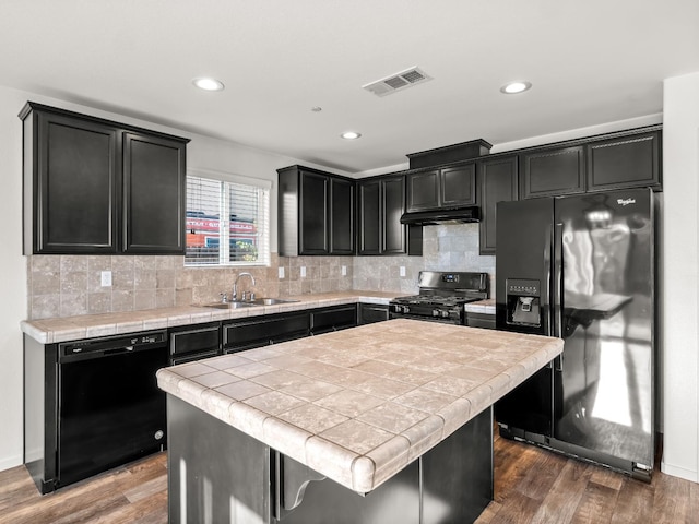 703 Tulip Cir, Dinuba, CA 93618 - kitchen featuring black appliances, a sink, dark cabinetry, tile countertops, and recessed lighting