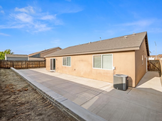 703 Tulip Cir, Dinuba, CA 93618 - back of house featuring central air condition unit, a patio area, a fenced backyard, and stucco siding