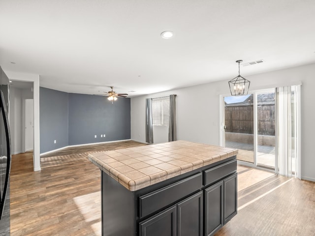 703 Tulip Cir, Dinuba, CA 93618 - kitchen featuring tile countertops, plenty of natural light, a ceiling fan, light wood finished floors, and recessed lighting