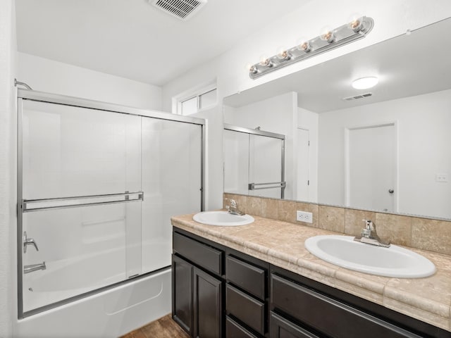 703 Tulip Cir, Dinuba, CA 93618 - full bath with double vanity, combined bath / shower with glass door, and wood finished floors
