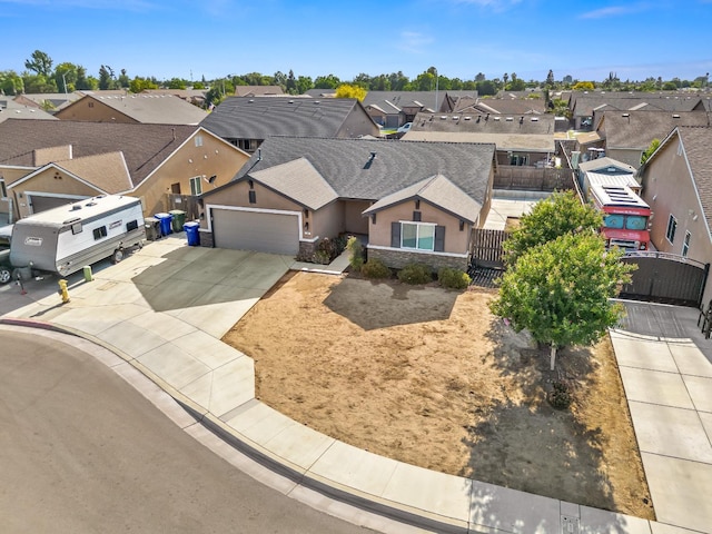 703 Tulip Cir, Dinuba, CA 93618 - view of front of property with a residential view, a garage, concrete driveway, a gate, and stucco siding